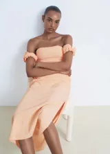 Vestido midi color salmón, de corte entallado con diseño palabra de honor, mangas cortas caídas abullonadas y tajo lateral en la falda.