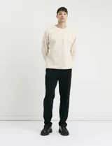 Pantalón jogging de corte recto, confeccionado en tejido circular con cintura elástica y cordón ajustable al tono. Presenta bolsillos laterales tipo parche.