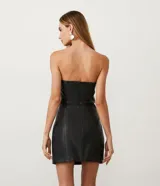 Vestido corto negro sin breteles confeccionado en material sintético con abertura en la pollera.