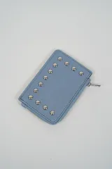 Billetera pequeña color negro con cierre de cremallera plateado y apliques de tachas metálicas redondas en la parte frontal.