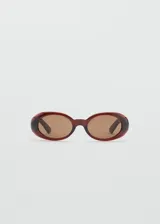 Gafas de sol con diseño ovalado y montura de pasta en tono rojizo oscuro. Cuentan con cristales marrones y protección UV categoría 3.