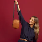 Bandolera de cuero sintético color negro, con doble cierre superior y correa de galón ajustable. Incluye un bolsillo interior de fácil acceso.