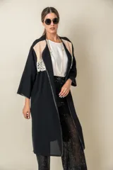 Túnica larga negra combinada con beige y aplique de blonda en la parte delantera. Tiene vivo de satén al tono y bolsillos laterales.