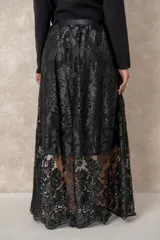 Pollera larga de tul con bordados florales en tono crema. Posee un forro interno opaco que llega hasta la rodilla, creando un efecto de transparencia en la parte inferior.