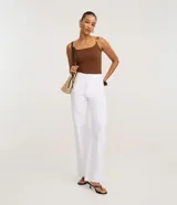 Body femenino ajustado, sin mangas, color verde oliva, con escote cuadrado y breteles finos dobles adornados con piezas decorativas. El tejido es texturizado.