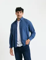 Camisa de franela lisa con cuello button-down, manga larga y bolsillo frontal. Presenta botones al tono y cierre frontal abotonado.