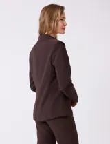 Blazer sastrero entallado color beige, con cuello de solapa, cierre frontal con un botón a tono y hombreras estructuradas. Presenta bolsillos laterales con solapa y forro interno.