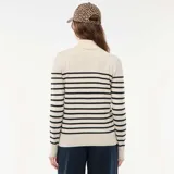 Sweater de punto con cuello alto, diseño de rayas horizontales negras sobre base beige, manga larga y ajuste al cuerpo.