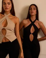 Top negro de lycra de seda suplex con hebilla de metal, escote halter cruzado y aberturas en el frente.