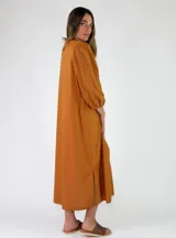 Vestido camisero largo de color naranja, con mangas largas abullonadas y cierre frontal de botones.