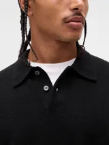Buzo tipo polo de tejido suave, con cuello clásico, cierre frontal de botones y puños y ruedo acanalados.
