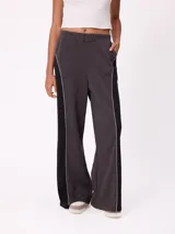 Babucha de corte holgado en color beige con paneles laterales en color fucsia y vivos blancos. Presenta cintura elástica y logo bordado en la parte superior.