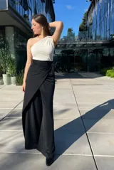 Pantalón negro de vestir con corte palazzo, cintura alta con lazo y abertura lateral.