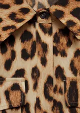 Vestido midi de diseño recto y sin mangas, con cuello camisero y cierre frontal de botones. Presenta dos bolsillos de parche en el pecho y un estampado de leopardo en tonos marrones.