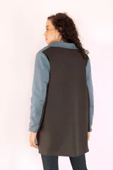 Tapado azul con solapas, cierre con botones, mangas largas con detalle de franja gris y bolsillos con ribete color crema.