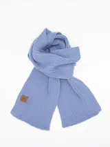 Bufanda de tejido de punto acanalado en color celeste, con etiqueta decorativa de cuero sintético en uno de sus extremos.
