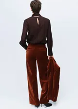 Pantalón de corte recto y tiro medio confeccionado en tejido de terciopelo. Cuenta con bolsillos laterales, bolsillos de ribete en la parte posterior, trabillas para cinturón y cierre oculto con botón, gancho y cremallera.