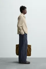 Cazadora color beige de algodón, corte recto, con cuello solapa, cierre frontal con cremallera, manga larga con puños abotonados y bolsillos laterales de ojal.