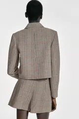 Falda pantalón de tiro medio con diseño de cuadros, bajo con abertura frontal y cierre lateral oculto.
