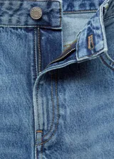 Jeans de corte recto y tiro medio, confeccionados en tejido de algodón estilo vaquero. Presentan cierre de cremallera con botón, trabillas en la cintura, dos bolsillos delanteros, bolsillo portamonedas y dos bolsillos de parche en la parte posterior.