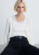 Musculosa blanca de punto canalé con ribete negro en cuello y sisas.