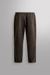 Pantalón jogger de corte relajado confeccionado en tejido compacto de algodón. Presenta cintura elástica con cordón interior, bolsillos frontales en la cadera y un bolsillo trasero de plastrón.