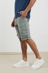Bermuda cargo de color verde, con diseño funcional de seis bolsillos, incluyendo bolsillos laterales con solapa. Confeccionada en tejido de algodón con elastano para mayor comodidad.