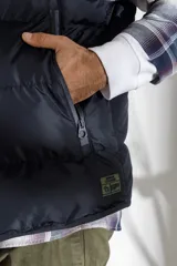 Chaleco acolchado azul marino con cierre frontal y cuello alto.