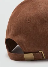 Gorro tipo gorra marrón con visera curva, cierre regulable metálico y diseño de seis paneles en tejido de algodón.