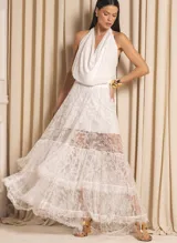 Conjunto de dos piezas negro compuesto por un top corto de encaje con volados y cuello redondo, y una falda larga de encaje con capas y transparencias.