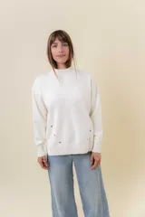 Sweater de tejido de punto color marrón, con cuello alto, corte relajado y terminaciones en rib en puños y cintura. Presenta una hilera de botones metálicos decorativos en uno de los laterales.