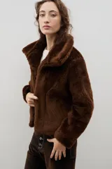 Campera corta de piel sintética en color crema, con cuello amplio tipo solapa y cierre frontal.