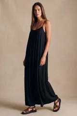 Vestido largo negro con tirantes finos, escote redondo y diseño holgado con frunces y pliegues verticales.