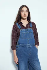 Camisa de corte relajado con estampado de cuadros en tonos bordó y marrón. Presenta cuello clásico, cierre frontal con botones y mangas largas con puños abotonados.