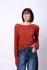 Top de manga larga confeccionado en microtul doble con diseño estampado gráfico en tonos marrón y rojo. Presenta un ajuste al cuerpo y escote redondo.