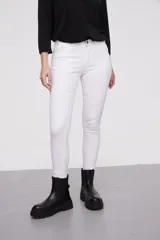 Pantalon jean de corte skinny y calce medio, color blanco, con bolsillos laterales y traseros.
