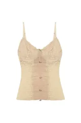 Musculosa de estilo corset confeccionada en tul beige con aplicaciones de encaje floral y cierre frontal con botones pequeños. Presenta breteles finos y un diseño semitransparente con frunces centrales.