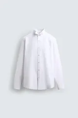 Camisa slim fit de algodón en color blanco, con cuello smoking y manga larga con puño doble abotonado.