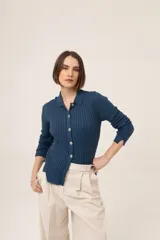 Camisa azul de punto 100% algodón con cuello polo, manga larga y cierre frontal con botones.