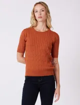 Buzo tejido marca Tahari, color verde, con cuello a la base, manga corta y diseño de ochos en el frente.