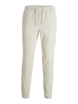 Pantalón tipo jogger de color beige claro, con cintura elástica ajustable mediante cordón. Presenta puños elásticos en los tobillos.