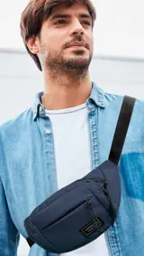 Riñonera azul marino de tafeta con tres bolsillos con cierre y correa de galón ajustable.