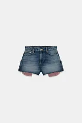 Shorts de jean tiro medio, corte mom fit, con bajo deshilachado y forro de bolsillos delanteros estampado a cuadros que asoma por debajo.