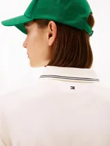 Chomba de piqué color blanco de Tommy Hilfiger, con mezcla de algodón elástico y lyocell. Presenta manga corta, cuello camisero con cierre frontal de cremallera y detalles de líneas oscuras en cuello, puños y dobladillo. Incluye logo bordado en el pecho.