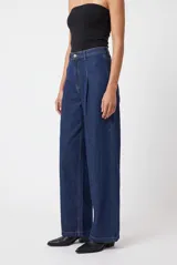 Pantalón de jean azul oscuro, de tiro alto y corte wide leg, con pinzas en la parte delantera.