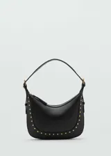 Bolso de hombro negro con diseño de media luna, confeccionado en efecto piel con detalle de tachuelas metálicas doradas en el contorno. Cuenta con asa ajustable y cierre de cremallera.
