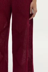 Pantalón de punto color bordó con diseño geométrico y estructura calada, de corte ancho y relajado.