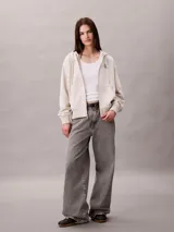 Buzo con capucha, cierre frontal de cremallera y bolsillos canguro, de color beige, con logo monograma de Calvin Klein bordado en el pecho.