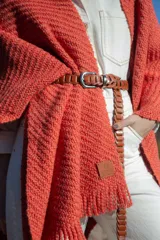 Ruana de tejido artesanal con textura en relieve, color naranja, con flecos en el ruedo y diseño envolvente.