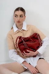 Cartera tipo bolso capitoneada de cuero color rojo, con asa de cadena plateada entrelazada con cuero. Forrada por dentro y con bolsillo interno.